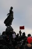 Protesters climb up the statue "Statue du Triomphe", which represents the French Republic, at the place de la Nation in Paris.