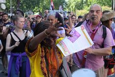 The protesters sing and dance in the street.