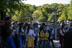 Ukrainian and Russian anti-war activists listen to a musical performance and the pro-Ukrainian space in Tiergarten Park.